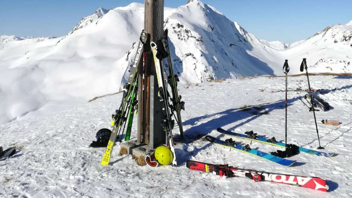 Gipfelkreuz mit aufgestellter Skiausrüstung