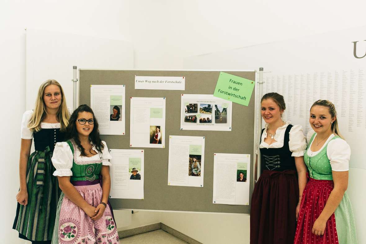 Vier Schülerinnen vor einem Plakat mit Försterinnen